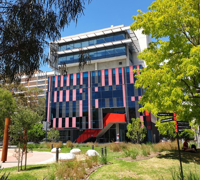 Swinburne University of Technology's Advanced Technologies Centre at Hawthorn, with its red entrance staircase, glass façade and campus lawn